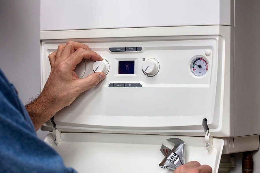 Technician adjusting controls during residential boiler installation service in Oxford MS