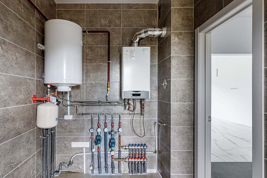 Modern boiler installation with piping and wall mounted unit indoors