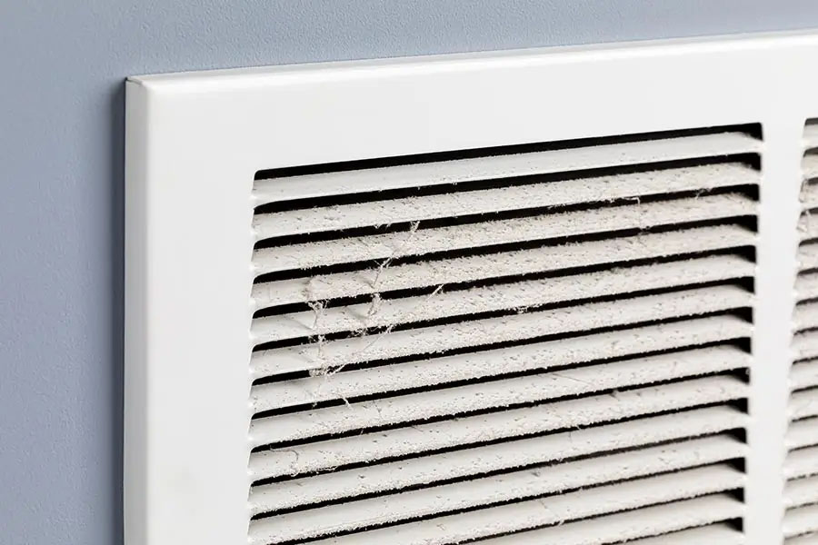 Dusty air vent grille needing HVAC ductwork repair and cleaning.